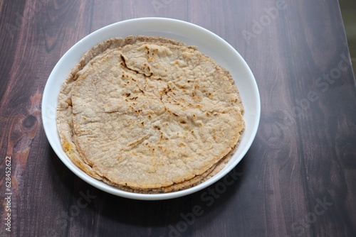Jowar flour flatbread known as bhakar or jawari bhakri. served with spicy garlic or lasun chutney, green chilli and onion. farmer's food. Maharashtrian village food. copy space