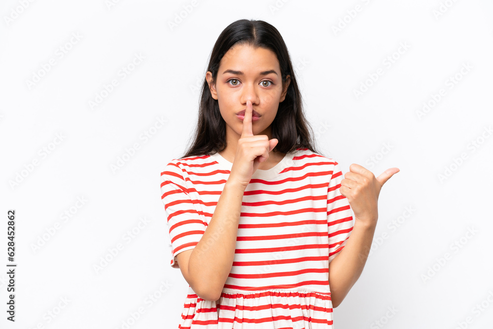 Young Colombian woman isolated on white background pointing to the side and doing silence gesture Young Colombian woman isolated on white background pointing to the side and doing silence gesture
