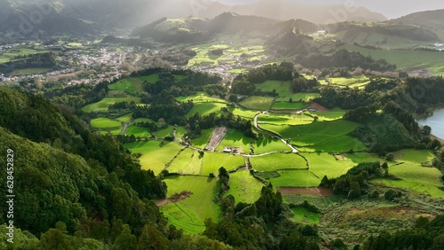 Aerial shot of green meadows, mountains and Furnas city on Sao Miguel Island, Azores, Portugal . Azores nature on sunny day 2