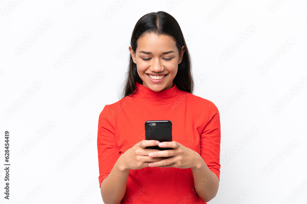 Young Colombian woman isolated on white background sending a message or email with the mobile Young Colombian woman isolated on white background sending a message or email with the mobile