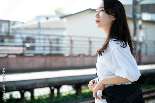 Young Asian woman tourists wait for the train at the station. Travelling on public transportation