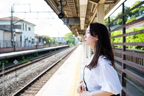 Young Asian woman tourists wait for the train at the station. Travelling on public transportation