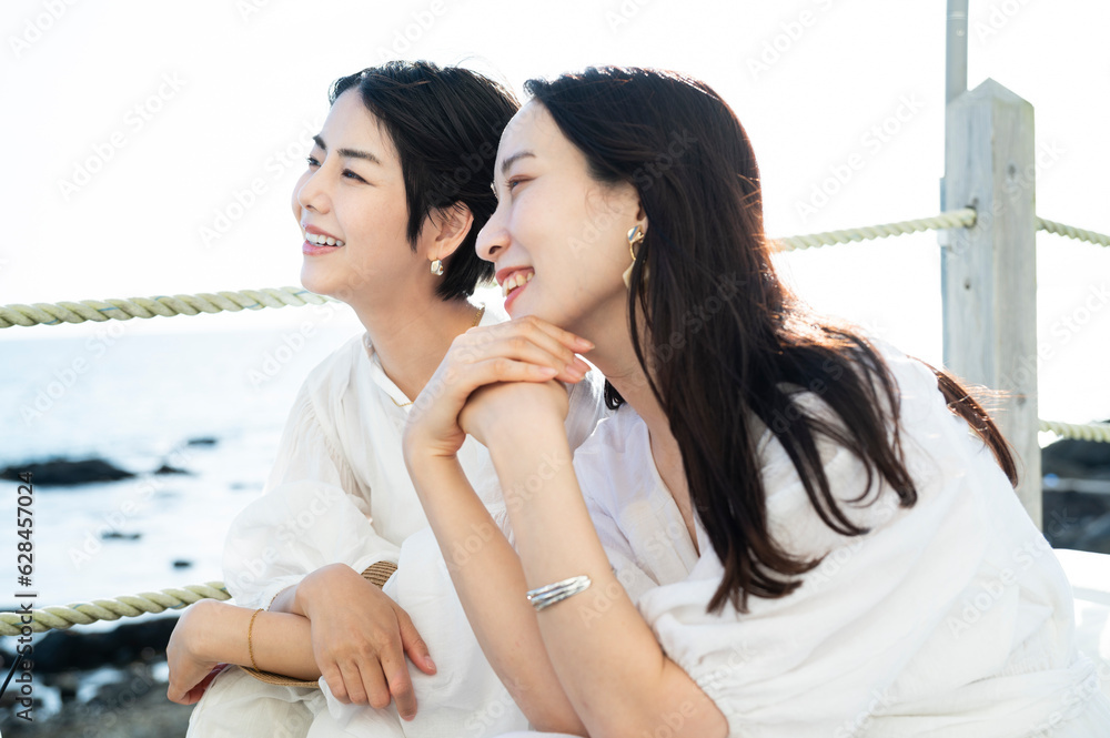 Young Asian females having fun at a seaside restaurant terrace, smiling joyfully
Friendship and vacation lifestyle. Young Asian females having fun at a seaside restaurant terrace, smiling joyfully
Friendship and vacation lifestyle.