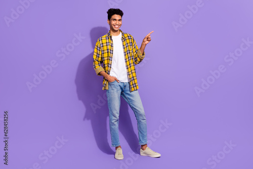 Full body photo of nice positive man put hand pocket indicate finger empty space isolated on violet color background © deagreez