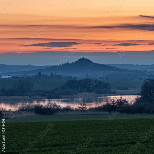 Sunrise. Contemplation in a quiet morning landscape. Czech paradise. In the background, the Zebín hill near Jičín, a pond.
