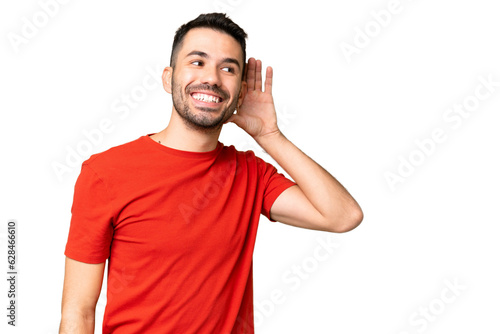 Canvastavla Young handsome caucasian man over isolated chroma key background listening to so