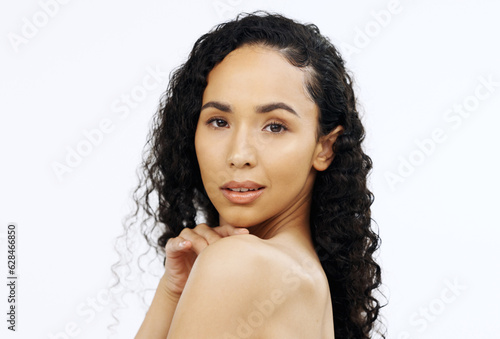 Face, beauty and skin with a model black woman touching her shoulder in studio on a gray background. Portrait, skincare and sensual with an attractive young female feeling her smooth or soft body