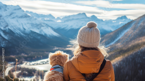 fluffy dog and woman. friend mood. snow, lake and mountain view background.