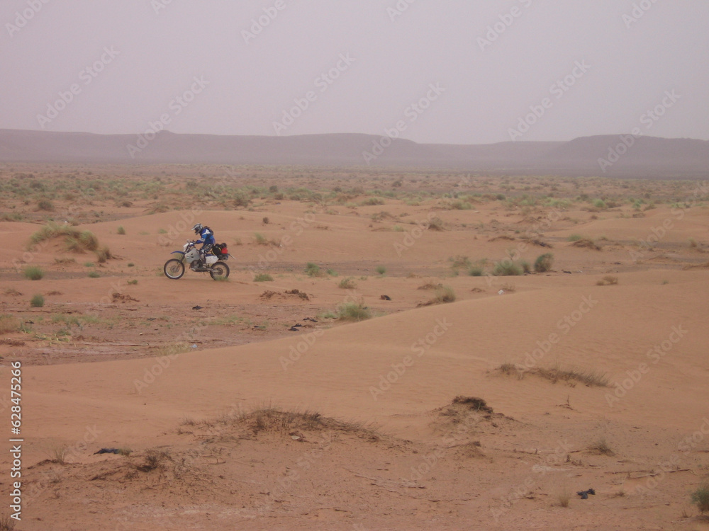Landscape of an enduro rider overcoming dunes: Adventurous rider navigating through a sea of sand.