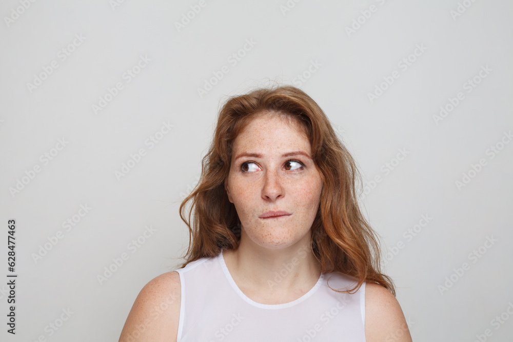 Fototapeta premium Thinking woman on white background. Doubt and idea concept