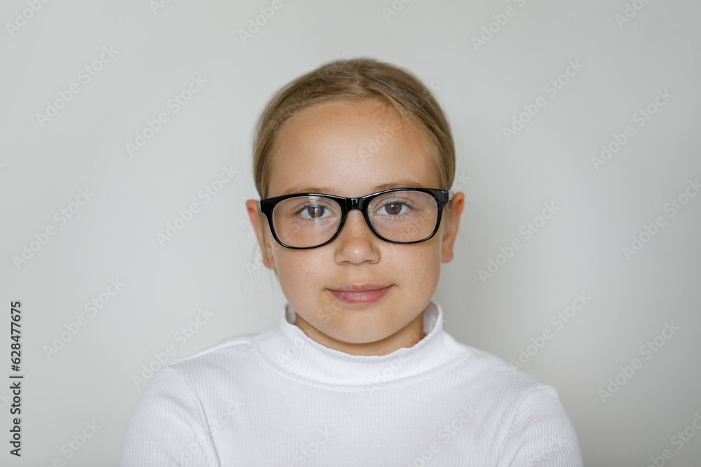 Clever child girl in glasses on white studio wall background Clever child girl in glasses on white studio wall background