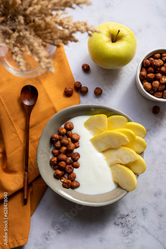 Breakfast bowl of yogurt with apple and hazelnuts	