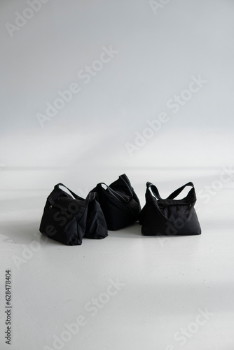 Three sand bags on a studio cyclorama. Photography studio sandbags for photographic equipment. Ballast for lighting stands. photo