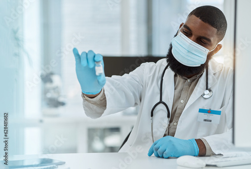 Medicine, vaccine and a doctor man with a mask for virus protection, health care and cure in hospital. Black person with a pharmaceutical product, vial or container for covid treatment or prevention