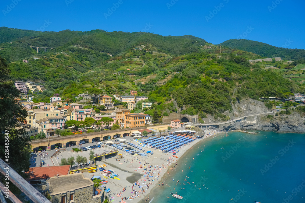 aerial view over beach chairs and umbrellas, houses, and train rail in Monterosso, Cinque Terre, The Ligurian Sea, Liguria, Italy, Italian Riviera