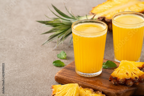 Bild auf Leinwand Fresh delicious pineapple juice smoothie in glass cup on gray table background