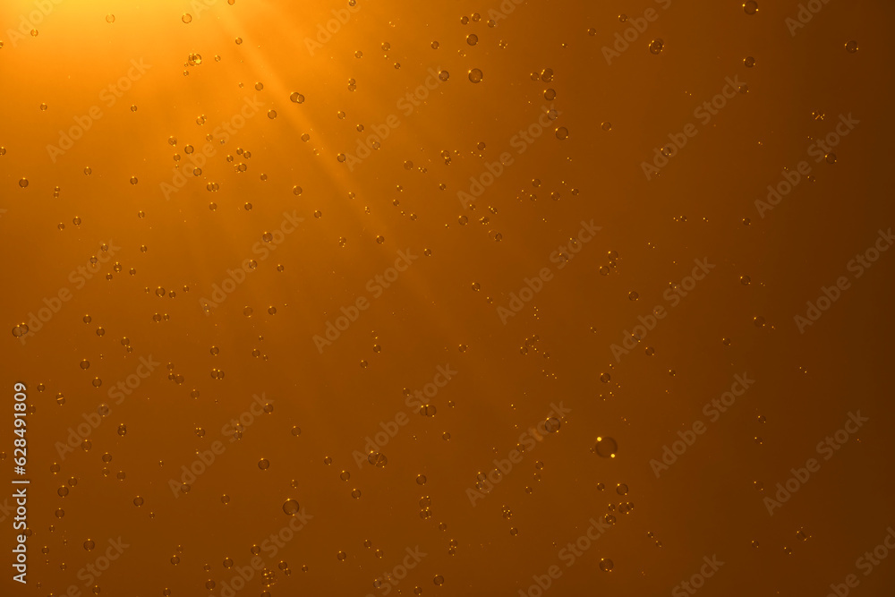 Soap bubbles in the orange sky. Beautifully iridescent balls of soap foam in the air with the rays of the sun