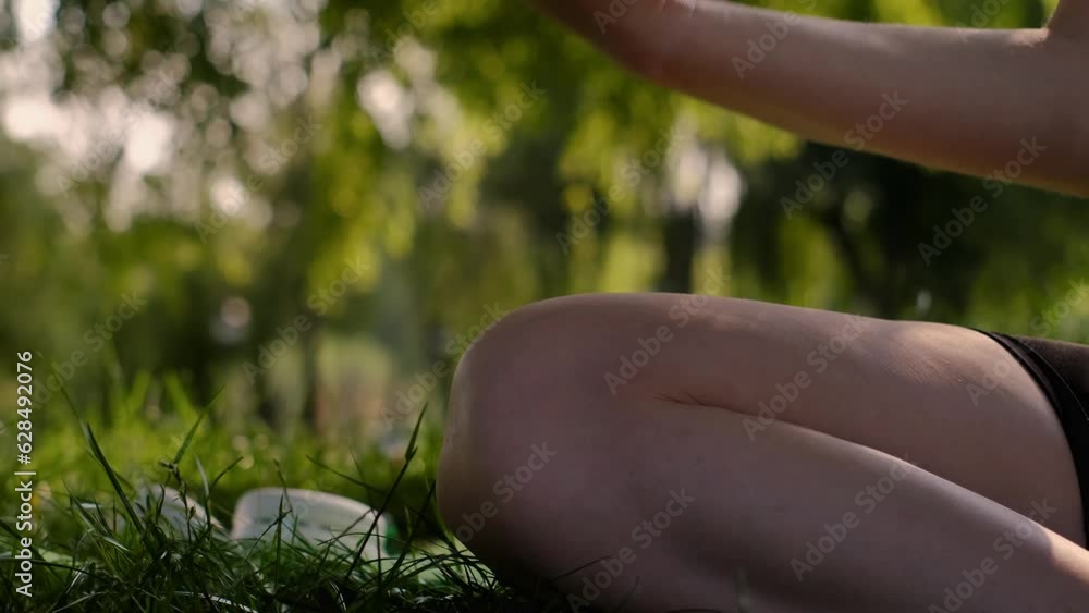 Young woman practices yoga in the garden. Healthy lifestyle and relaxation concept. A young girl is doing yoga in the park.meditation, enjoyment of nature