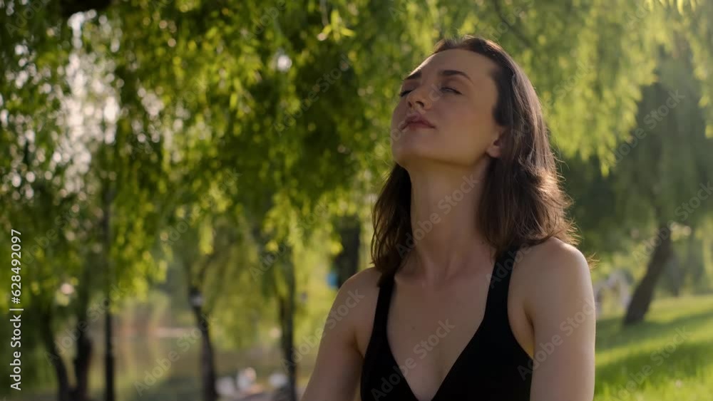 Young woman practices yoga in the garden. Healthy lifestyle and relaxation concept. A young girl is doing yoga in the park.meditation, enjoyment of nature Young woman practices yoga in the garden. Healthy lifestyle and relaxation concept. A young girl is doing yoga in the park.meditation, enjoyment of nature