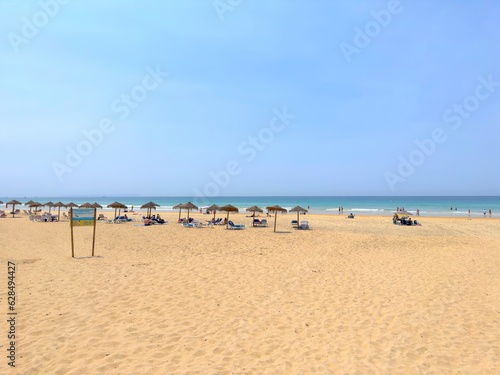 Fototapeta Naklejka Na Ścianę i Meble -  view of the beautiful sandy beachPlaya del Cabo de la Plata with parasols and sunbeds in Zahara de los Atunes, Costa de la Luz, Andalusia, province of Cádiz, Spain, Travel, Tourism