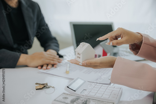 Male businessman or real estate agent holding house key for his client after signing contract in office concept for real estate Moving house or renting property 