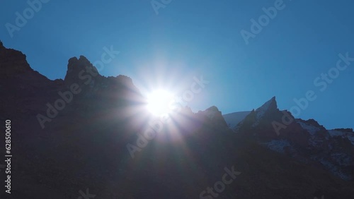 Sun rising above the snowy mountain peaks of Himalayas at Zanskar valley in Ladakh, India. View of the sun above the mountain peaks during the sunrise. Natural sunrise background in the mountains. photo