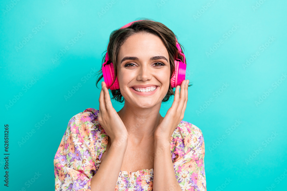 Portrait of adorable positive girl beaming smile hands touch headphones new single hit isolated on turquoise color background Portrait of adorable positive girl beaming smile hands touch headphones new single hit isolated on turquoise color background