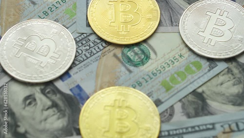Gold and silver bitcoin coins lie on the table with dollars close up