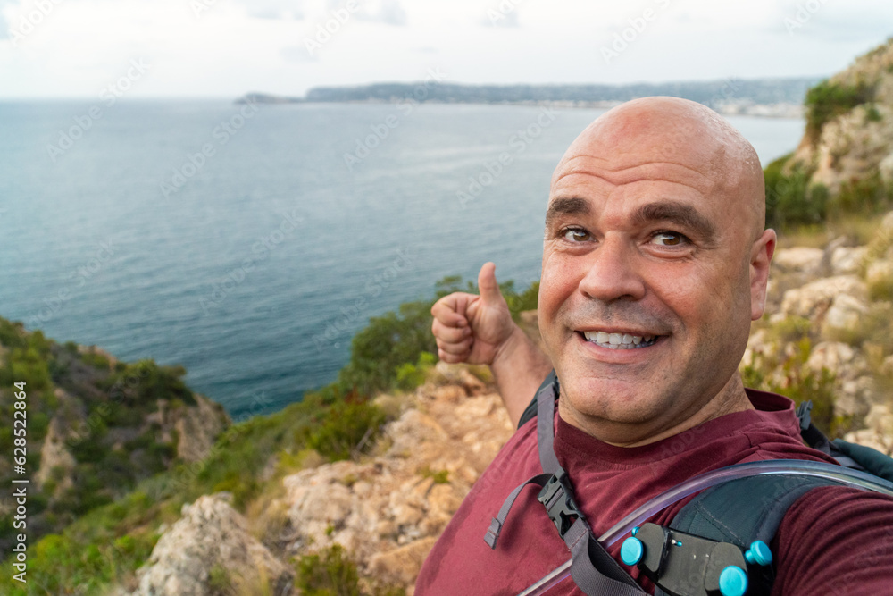Smiling happy man takes a selfie with a beautiful natural background Smiling happy man takes a selfie with a beautiful natural background