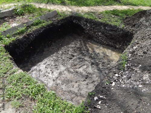 Deep square trench.. A hole dug for a foundation. 