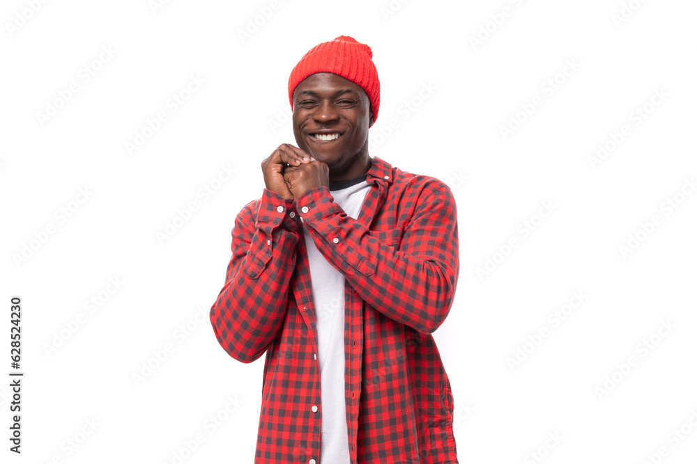 portrait of handsome 30s black american man dressed in red shirt and cap on white studio background with copy space portrait of handsome 30s black american man dressed in red shirt and cap on white studio background with copy space