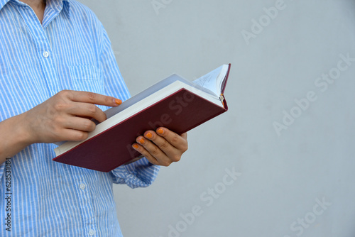 Young woman holding book in her hands , with space for text