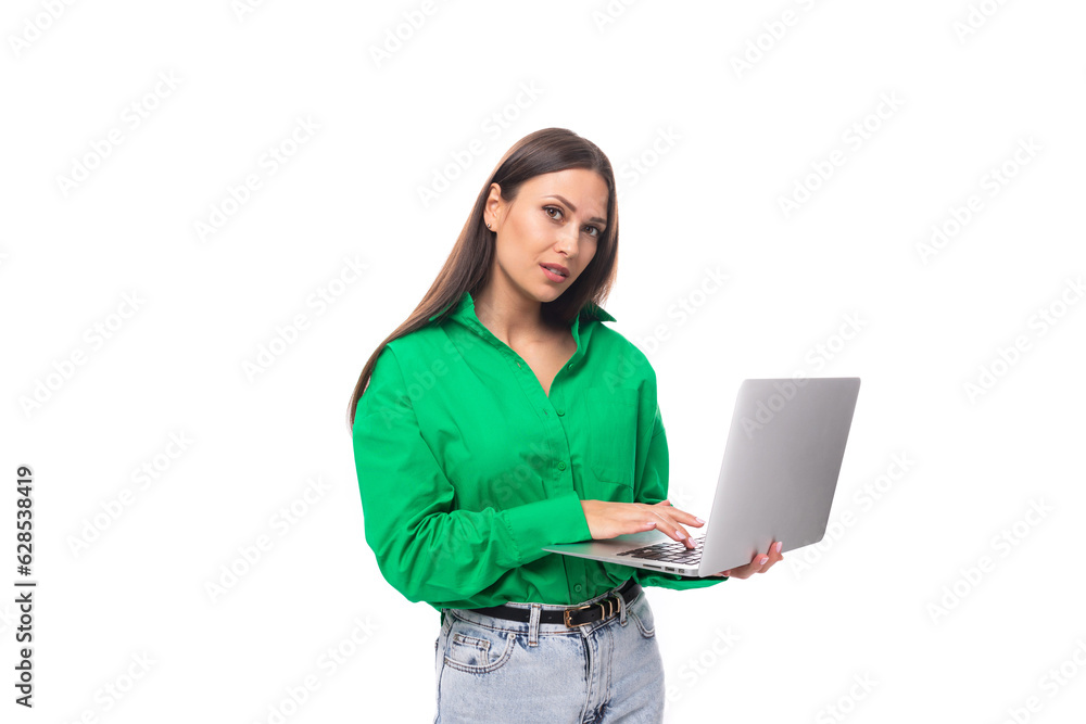 young european brunette woman with brown eyes in green blouse works online using laptop young european brunette woman with brown eyes in green blouse works online using laptop