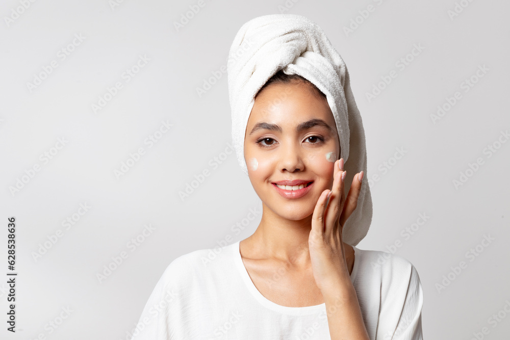 Woman applying anti-wrinkle eye cream. girl wearing bath towel on head portrait. Woman applying anti-wrinkle eye cream. girl wearing bath towel on head portrait.