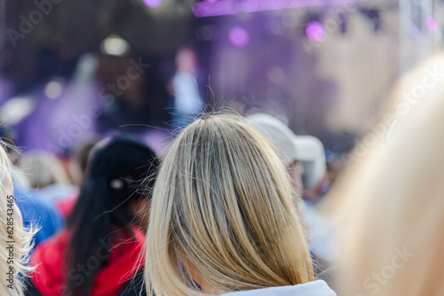 Young blonde Woman At Outdoor celebrates at the Music Festival.