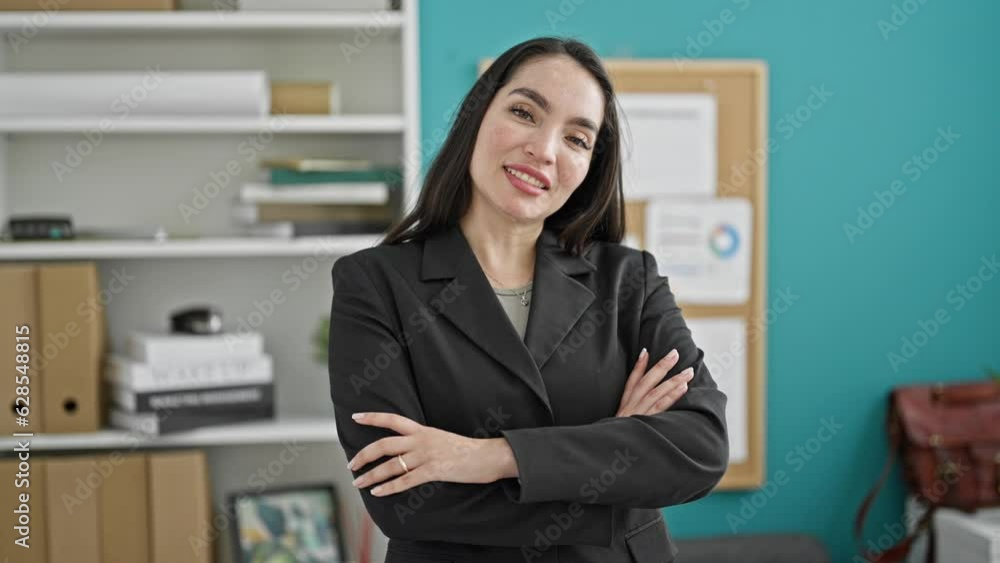 Young beautiful hispanic woman business worker smiling confident standing with arms crossed gesture at the office Young beautiful hispanic woman business worker smiling confident standing with arms crossed gesture at the office