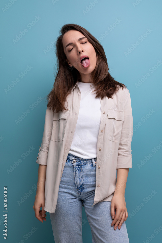 young brunette female adult in casual shirt grimacing young brunette female adult in casual shirt grimacing