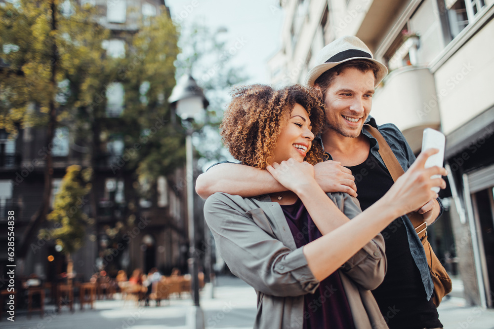 Young couple using a smart phone while traveling and exploring the city on their vacation Young couple using a smart phone while traveling and exploring the city on their vacation