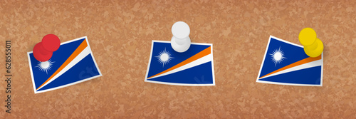 Marshall Islands flag pinned in cork board, three versions of Marshall Islands flag.