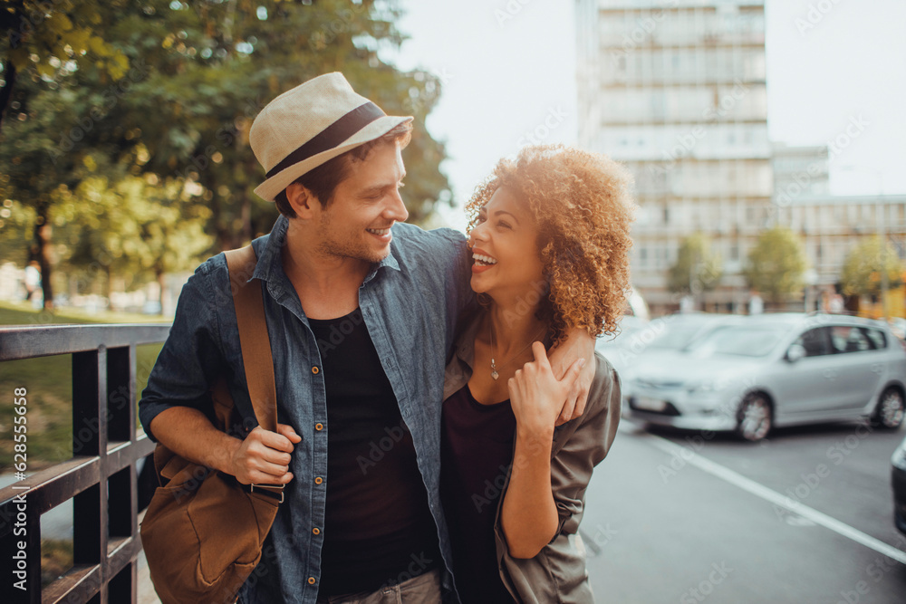 Fototapeta premium Young couple walking down a street in the city while traveling on their vacation