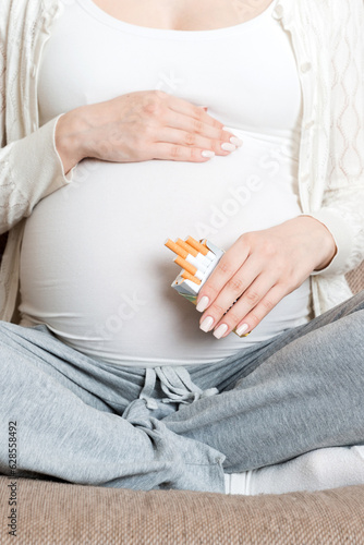 Pregnant woman with cigarette at home. mother smoking concept