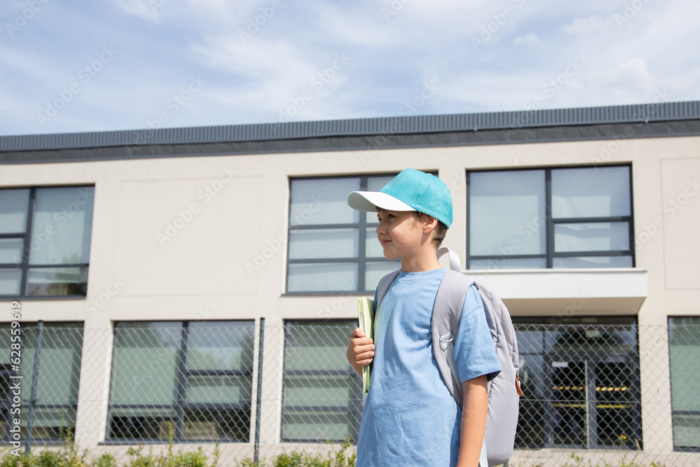 custom made wallpaper toronto digitalthe child goes to school, the boy goes home from school. the child is standing near the school. a boy in a blue T-shirt, a gray backpack, a cap.