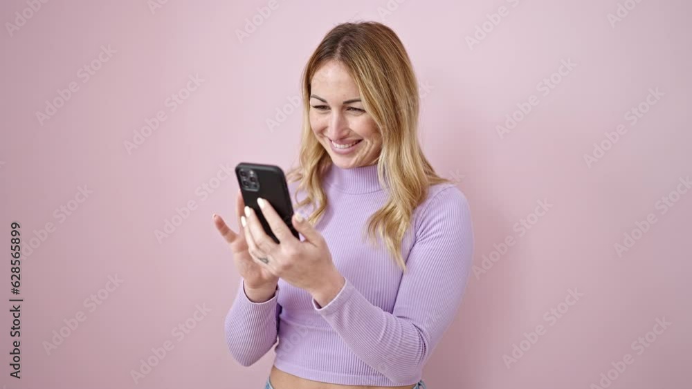 Young beautiful hispanic woman using smartphone smiling over isolated pink background Young beautiful hispanic woman using smartphone smiling over isolated pink background