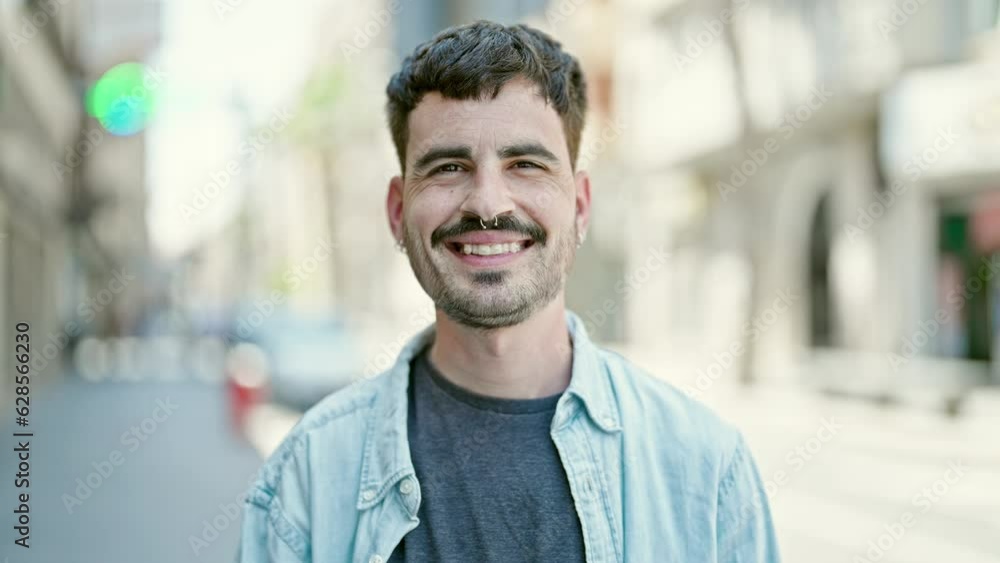 Young hispanic man smiling confident standing at street