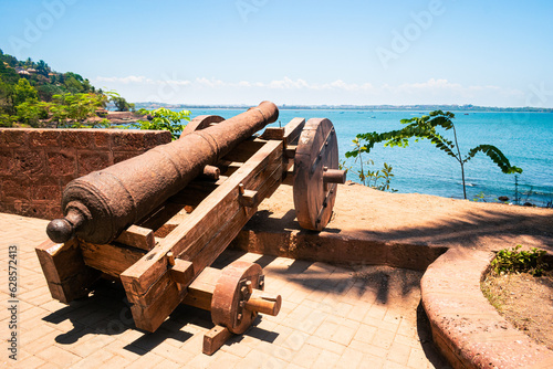 Old cannon on the candolim beach at Goa, India photo