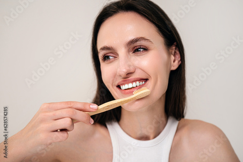 Portrait of smiling woman holding bamboo toothbrush
