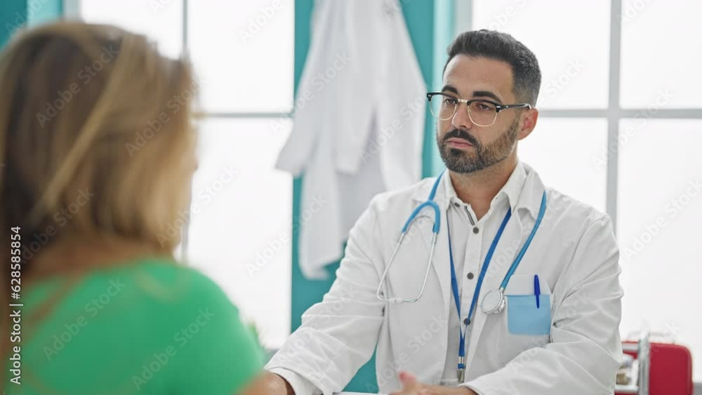Man and woman doctor having medical consultation speaking with patient at the clinic Man and woman doctor having medical consultation speaking with patient at the clinic