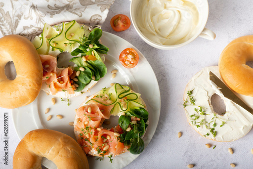 Food, lunch, brunch, meal on a plate, plating concept. Bagels with smoked salmon, cream cheese and capers on a table.