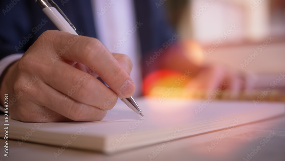Businessman writing on notebook in office on table. Concept of finance planing and analyzes business and growth. working from home concept... Businessman writing on notebook in office on table. Concept of finance planing and analyzes business and growth. working from home concept...