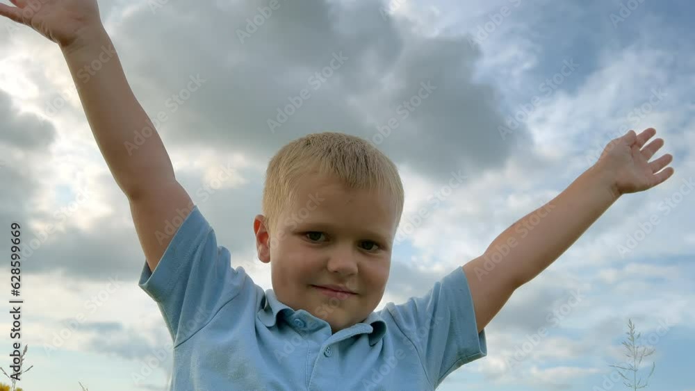 Happy child. worship and prayer of the child for health and happiness, hands raised to the sky. Silhouette of child against a colorful sky serves as a symbol of hope, faith and optimism Happy child. worship and prayer of the child for health and happiness, hands raised to the sky. Silhouette of child against a colorful sky serves as a symbol of hope, faith and optimism